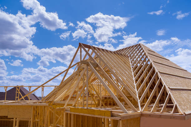 Aerial top view of wooden structure roof truss frame installation by under the construction house